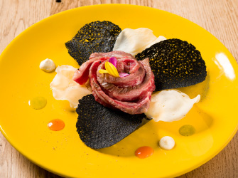 Black truffle Wagyu Tataki with orange gel, nettles and mint, with anchovy sauce and cuttlefish ink coral crisp
